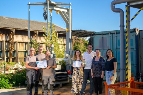 Photo de notre équipe devant l'enrouleuse à flexibles automatisée