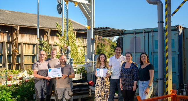 Photo de notre équipe devant l'enrouleuse à flexibles automatisée