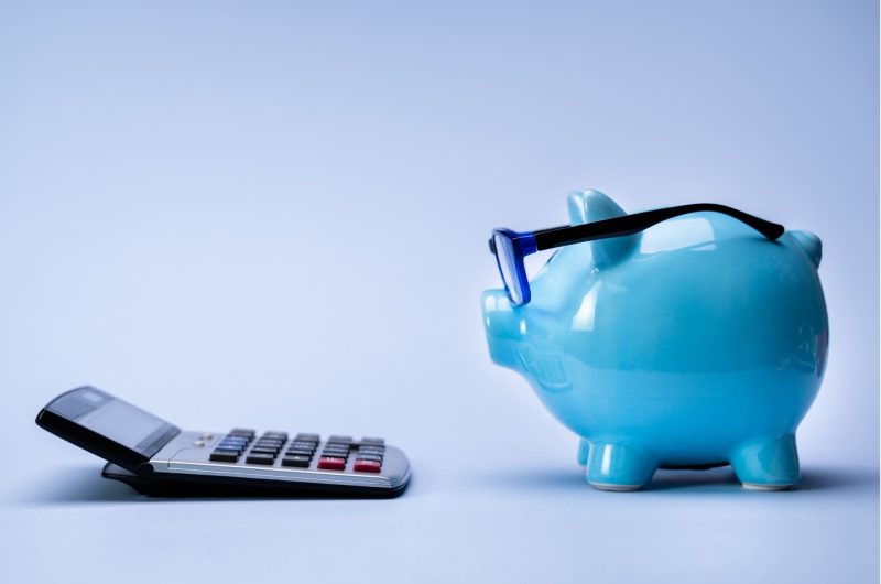 Photo d'une tirelire et d'une calculatrice pour représenter la gestion budgétaire