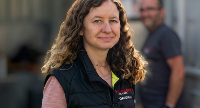 Photo de Christelle Dubois en charge de la SSE, devant une chaudière containérisée